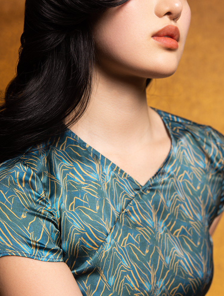 An asian model wears the SPRING MOUNTAINS silk crop top which features  a Chinese cross collar neckline.