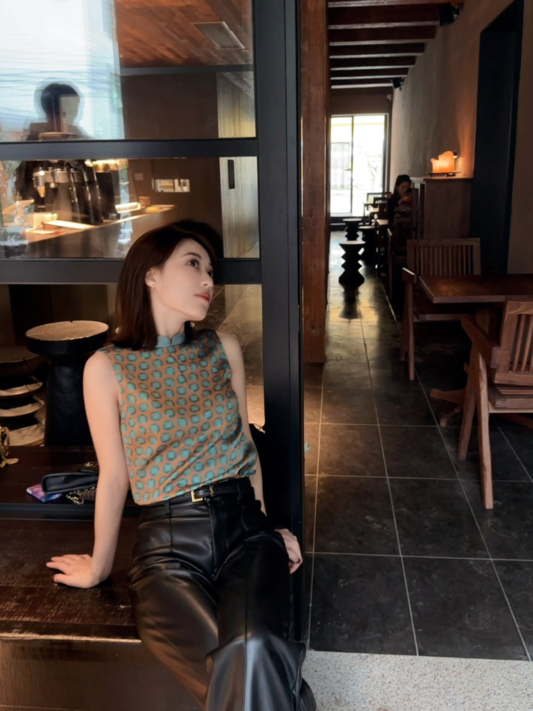 A women wears a silk sleeveless top featuring a custom print and Mandarin collar, exuding grace in a Modern Chinese chic style.