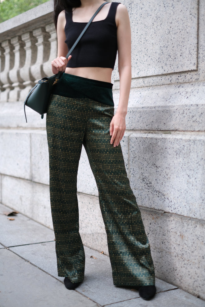 A woman wears a silk crop top and high-waisted pants set in New York. The set features the VELVET POEM Print and is inspired by Chinese landscape paintings. She exudes grace in this Modern Chinese chic style.