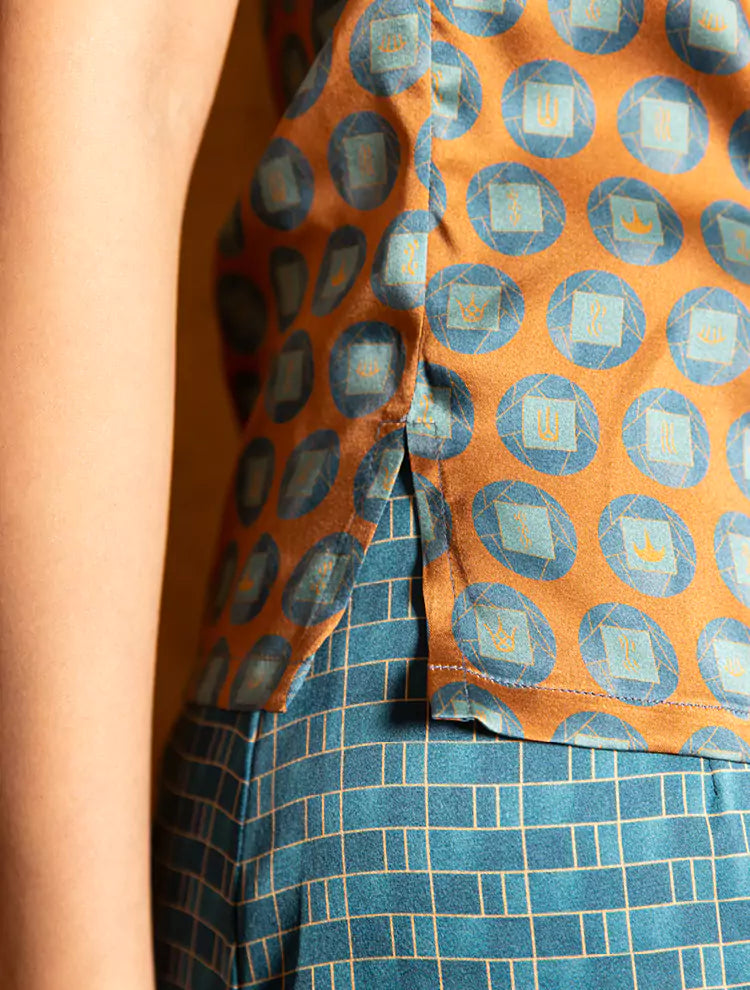 This picture shows a close up of a silk sleeveless top featuring a custom print and Mandarin collar. 