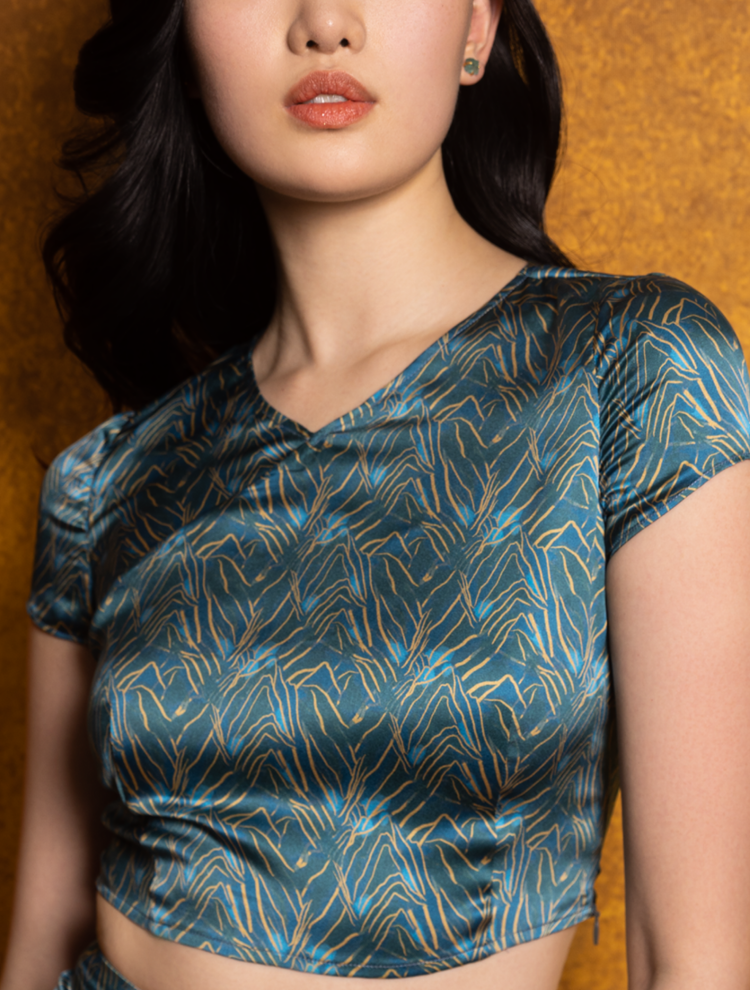 An asian model wears the SPRING MOUNTAINS silk crop top which features  a Chinese cross collar neckline. 