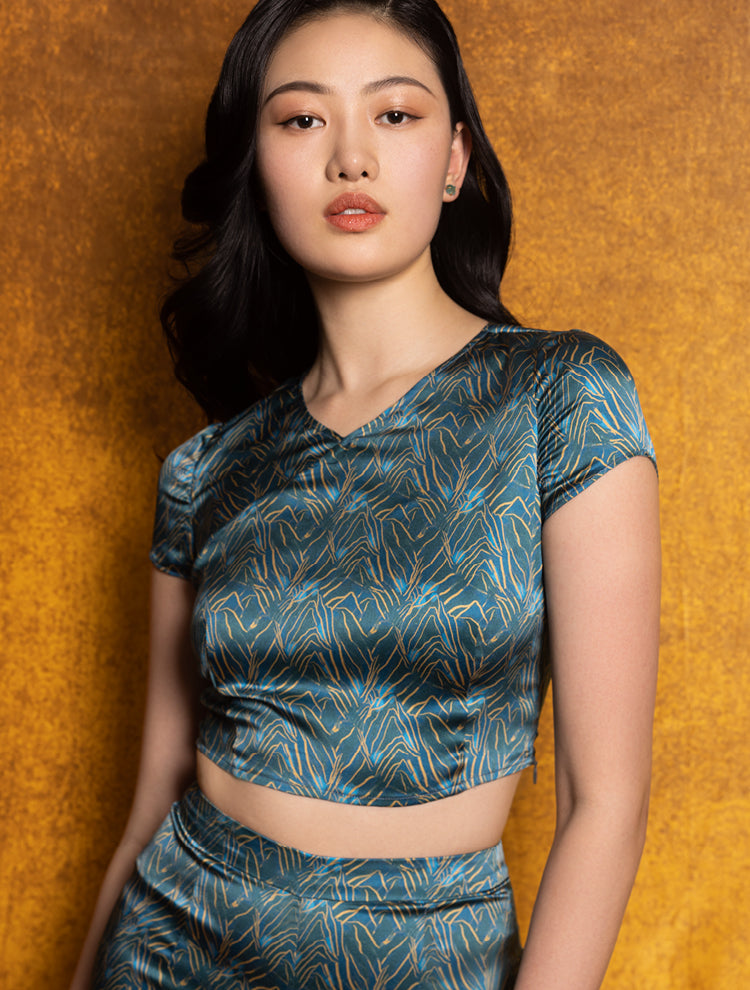 An asian model wears a silk crop top and shorts set featuring the SPRING MOUNTAINS Print. She exudes grace in this Modern Chinese chic style. 
