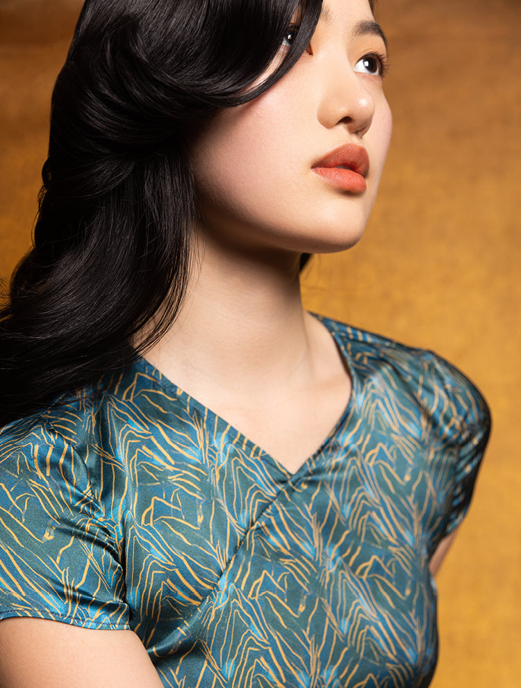 An asian model wears a silk crop top featuring the SPRING MOUNTAINS Print. She exudes grace in this Modern Chinese chic style. 