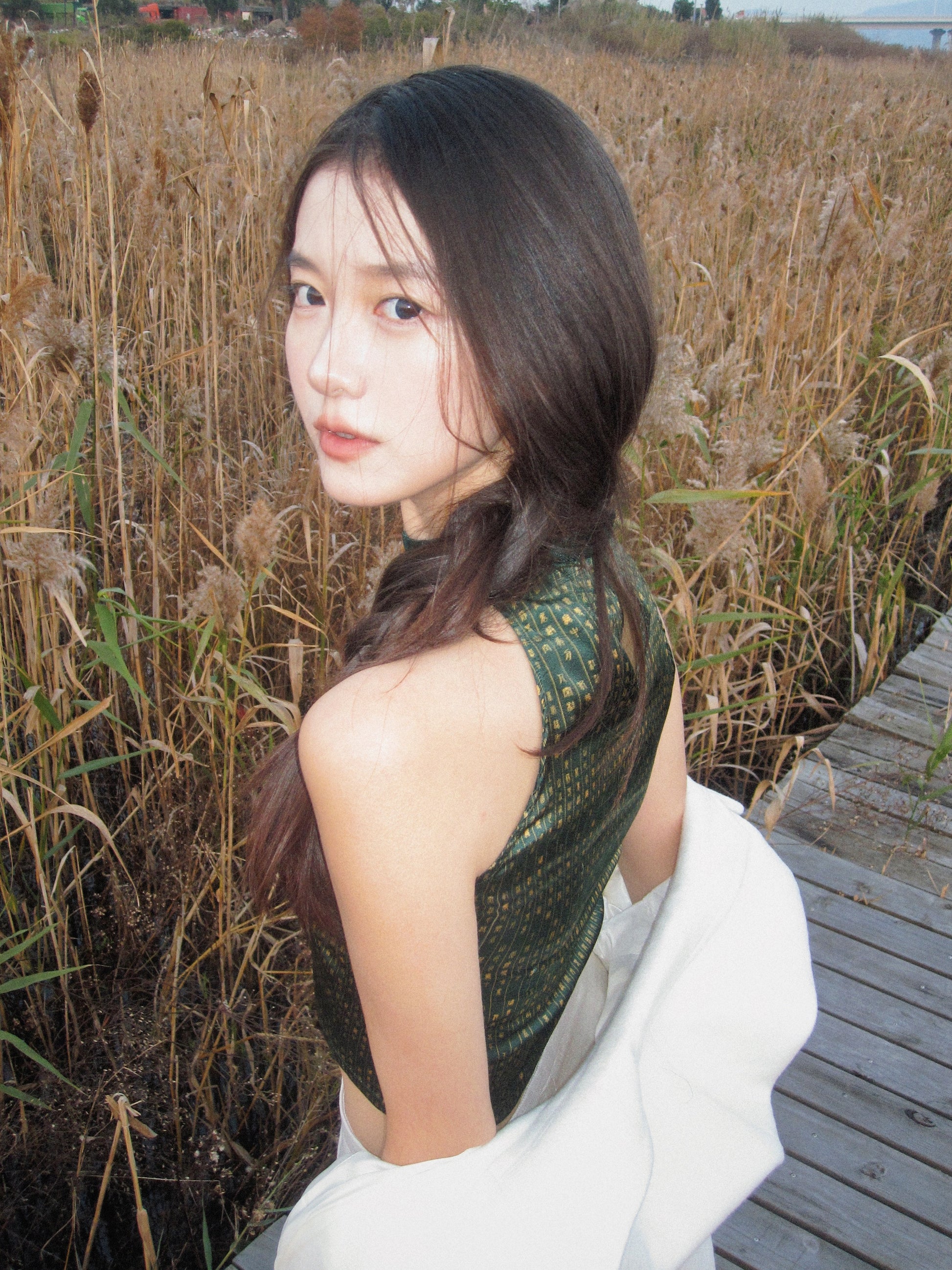 A woman wears a silk crop top featuring the VELVET POEM Print, which is inspired by Chinese landscape poetry. She exudes grace in this Modern Chinese chic style. 